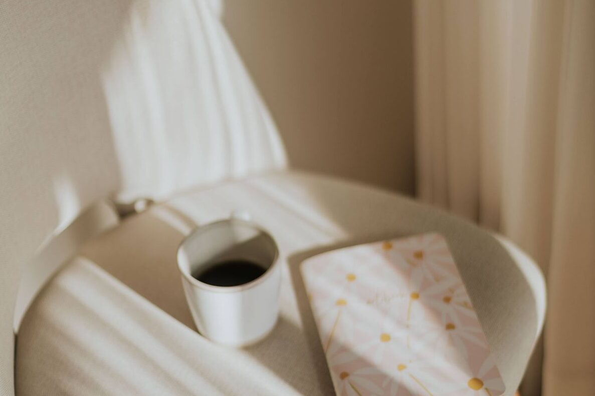 朝の柔らかい光の中のノートとコーヒーのイメージ